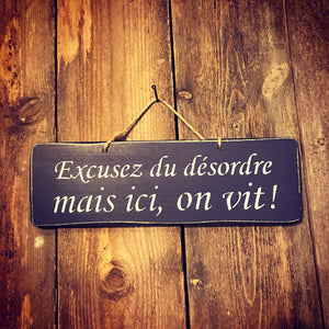 Pancarte :"Excusez du désordre mais ici on vit"